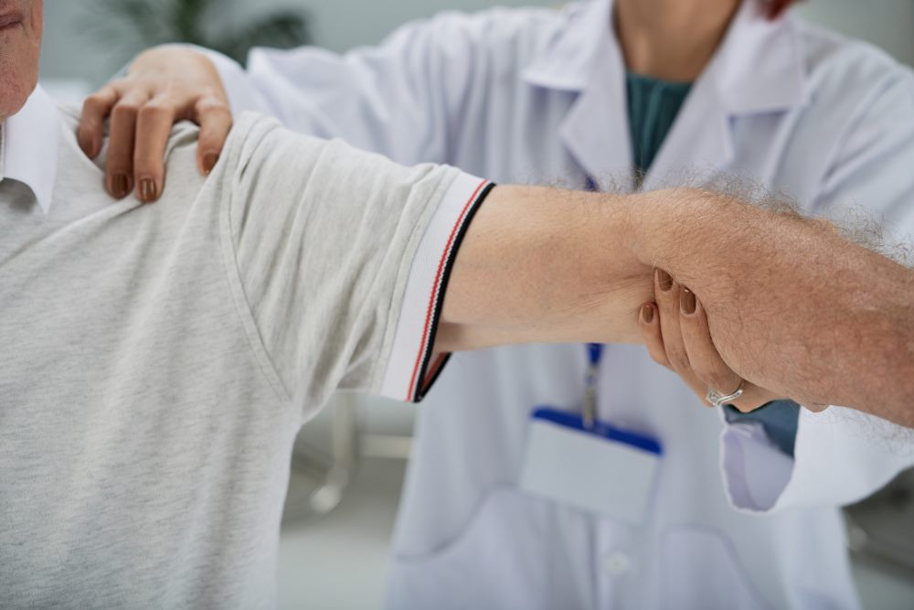Doctor examining a patient’s shoulder for frozen shoulder stiffness.